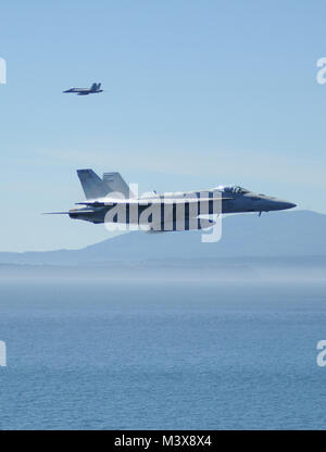 PUGET SOUND, Wash. (July 31, 2014) F/A-1E Super Hornets assigned to the Argonauts of Strike Fighter Squadron (VFA) 147 fly over the aircraft carrier USS Nimitz (CVN 68) during a friends and family day cruise airshow. Nimitz returned to Naval Station Everett after hosting more than 400 friends and family members during a one-day cruise. (U.S. Navy photo by Mass Communication Specialist 3rd Class Kelly M. Agee/Released) 140731-N-AZ866-335.jpg by USS NIMITZ (CVN 68) Stock Photo