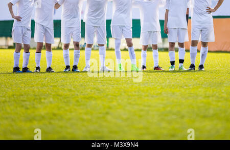 Youth Football Team. Young Soccer Players Standing in Row. Boys Standing Together During Penalty Shots. Boys in White Soccer Jersey Shirts