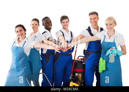 Group Of Happy Janitors Stacking Hands Isolated On White Background Stock Photo