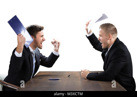 Two Young Businessmen Shouting At Each Other On White Background Stock Photo