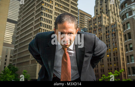 Portrait of a  businessman leaning over looking directly into camera in a city / urban location. Stock Photo