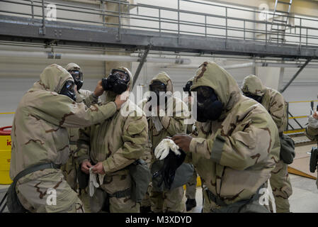 Col. Ethan Griffin, 436th Airlift Wing commander, (far left) performs a buddy check of another Airman’s Mission Oriented Protective Posture, also known as MOPP gear, during a Chemical, Biological, Radiological and Nuclear (CBRN) training session Jan. 31, 2018, at Dover Air Force Base, Del. When worn properly, MOPP gear provides an airtight seal, completely encapsulating the wearer. (U.S. Air Force photo by Staff Sgt. Aaron J. Jenne) Stock Photo