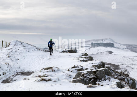 Hadrian's Wall: a jogger heads east on Highshield Crags, above Crag Lough, with Winshield Crags also visible in the distance Stock Photo