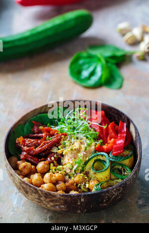 Vegan Buddha bowl with chickpeas, courgette, sundried tomatoes and sprouts Stock Photo