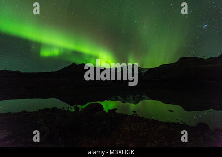 Green aurora light behind Lake mountain in iceland europe at national park skaftafell Stock Photo