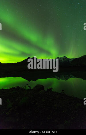 Green aurora light behind Lake mountain in iceland europe at national park skaftafell Stock Photo