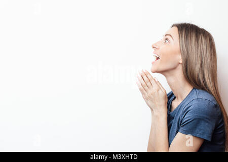 Happy girl. Portrait. Asks.  With copy space. Empty palm of  woman holding a virtual object, asking or offering something. Conceptual mockup for adver Stock Photo