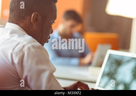 Smiling young man using digital tablet in the office Stock Photo