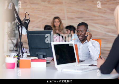 Happy smiling successful African American businessman in in a modern bright startup office indoors Stock Photo