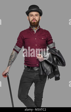 Tattooed bearded man with walking stick. Stock Photo