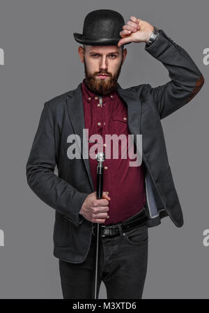Tattooed bearded man in a suit holding cane Stock Photo