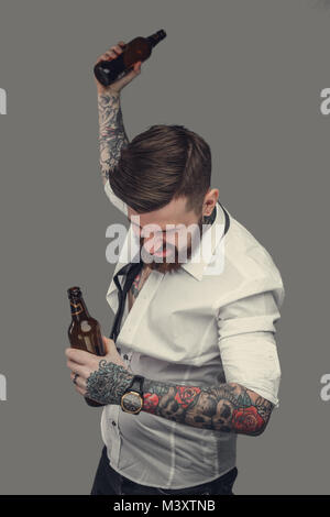 Drunk tattooed bearded man in a white shirt. Stock Photo