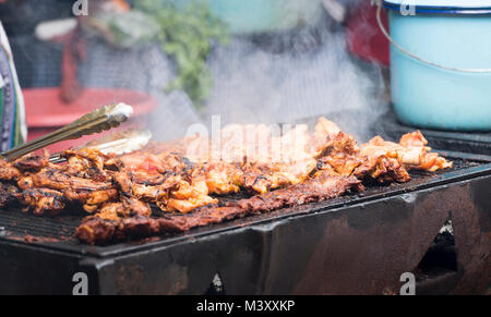 Grilled chicken being cooked on a barbecue at a town fair in Guatemala Stock Photo