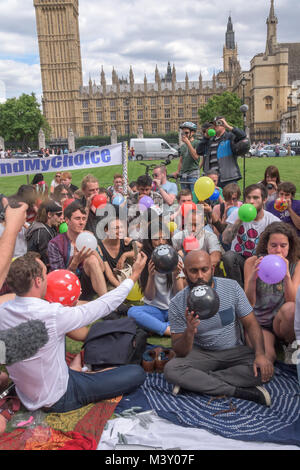 As Big Ben struck three o'clock the mass inhalation of nitrous oxide (laughing gas) in Parliament Square in protest against proposed legal ban on psychoactive substances began. Stock Photo