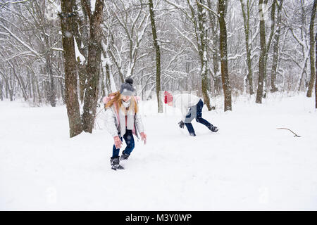 Teenage couple having fun in snow white background Stock Photo
