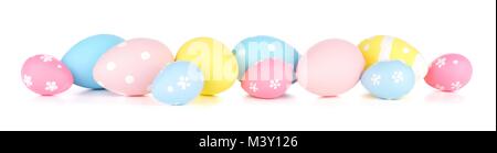 Easter eggs scattered forming a long border. Isolated on a white background. Blue, yellow and pink colors. Stock Photo