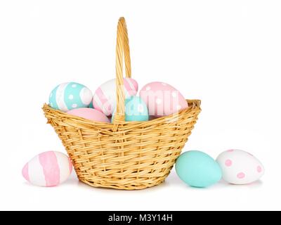 Easter basket filled with colorful hand painted pink, blue and white Easter Eggs over a white background Stock Photo