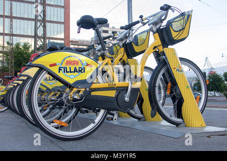HELSINKI, FINLAND, JUL 03 2017, New yellow bicycles for rent stand at row on the pavement. Bike urban transport at Helsinki. Modern concept of ecologi Stock Photo
