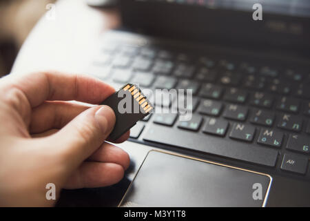 Stick in hand, laptop, keyboard flash drive information Stock Photo