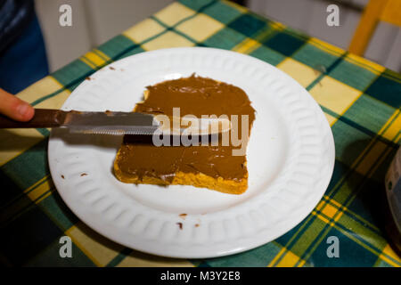 bread with hazelnut cream and chocolate spread with knife on the kitchen table Stock Photo