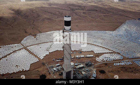 Solar power plant mirrors that focus the sun's rays upon a collector tower to produce renewable, pollution-free energy - Aerial image Stock Photo