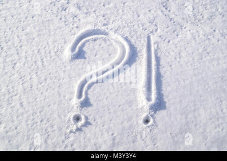 Question mark and exclamation mark on white snow. Question. Exclamation. Painted on solid snow Stock Photo