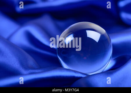 glowing crystal ball shot on blue satin Stock Photo