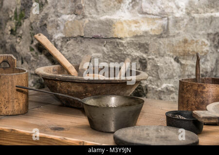 Medieval kitchen with tools, baskets, scale, fireplace Stock Photo