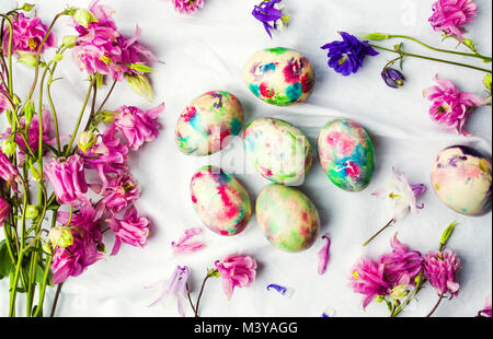 Easter eggs and colorful iris flowers on white textile background Stock Photo