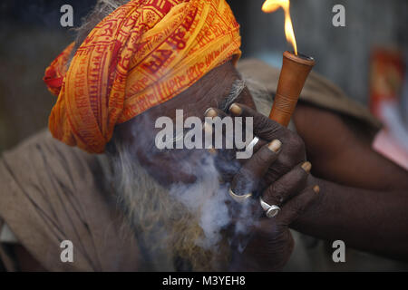 Kathmandu, Nepal. 13th Feb, 2018. A Sadhu or holy man smokes a marijuana chillum during Maha Shivaratri festival inside Pashupatinath Temple in Kathmandu, Nepal on Tuesday, February 13, 2018. Thousands of sadhus from India and Nepal come to celebrate the festival of Maha Shivaratri by smoking marijuana, smearing their bodies with ash and offering prayers devoted to the Hindu Deity Lord Shiva. Credit: Skanda Gautam/ZUMA Wire/Alamy Live News Stock Photo