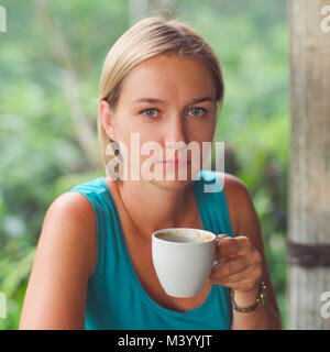 Coffee. Beautiful Girl with glasses drinking Tea or Coffee in cafe. Stock Photo