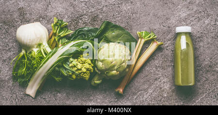Green organic vegetables smoothie with chard, fennel, artichokes and rhubarb  in bottle on gray granite table , top view. Healthy dieting and antioxid Stock Photo