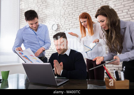 Mature Male Executive Saying Sorry To His Colleague By Joining Two Hands In Office Stock Photo