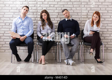 Business People Are Getting Bored While Sitting On Chair Waiting For Job Interview In Office Stock Photo