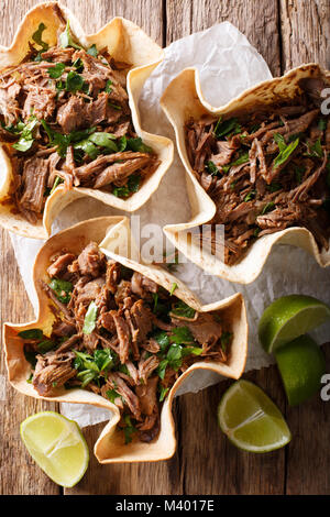 Mexican barbacoa tacos with spicy pulled beef close-up on the table. Vertical top view from above Stock Photo