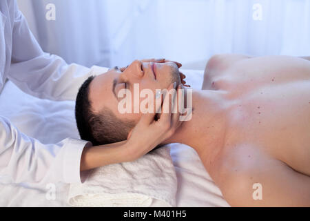 male masseuse makes a therapeutic massage in the Spa Stock Photo