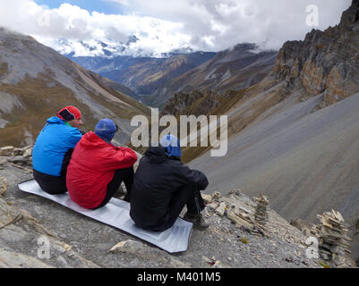 Looking down to the valley, Tourists looking to the Annapurna Mountain Range from Thorong High Camp - Annapurna Circuit Trek in Nepal Stock Photo