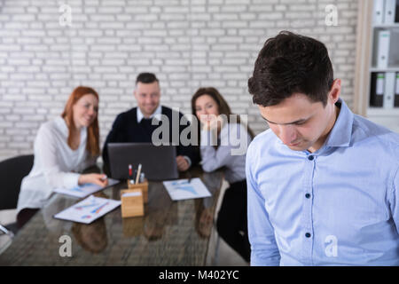 Portrait Of A Businessman With His Colleagues In Background At Office Stock Photo