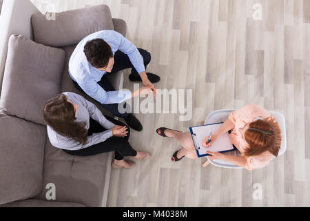 Elevated View Of Couple Sitting On Couch With Psychologist Stock Photo