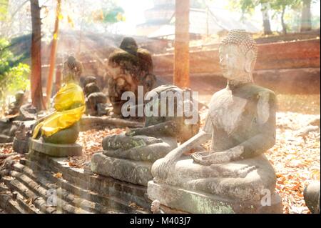 Ancient outdoor Buddhas field of broken sculpture in Wat Umong Suan Puthatham.The temple is a 700 year was built in 1297 in Chiang Mai city, Thailand. Stock Photo