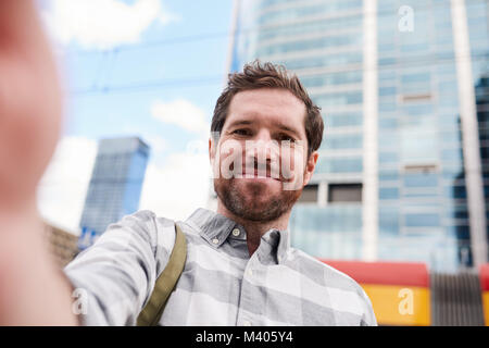 Smiling young man taking a selfie in the city Stock Photo