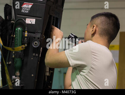 Airman 1st Class Shu Hsu, 18th Component Maintenance Squadron egress systems journeyman, performs a visual inspection on an F-15 Eagle ejection seat Feb. 7, 2018, at Kadena Air Base, Japan. Hsu enjoys the specialization of his job and takes great pride in practicing excellence with his tasks. (U.S. Air Force photo by Senior Airman Jessica H. Smith) Stock Photo