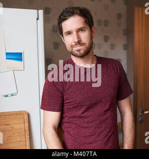 Handsome man standing in his modern kitchen in the morning Stock Photo