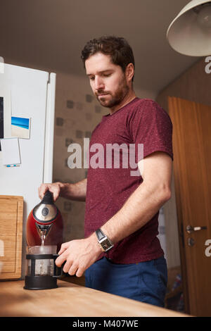 Young man making coffee in his kitchen at home Stock Photo