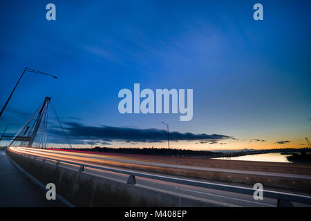 Walking along the port mann bridge at magic hour with the sun setting in the back ground.2 Stock Photo
