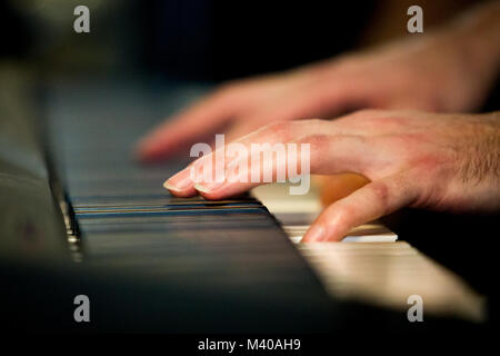 Close up male hands playing electric piano indoors Stock Photo