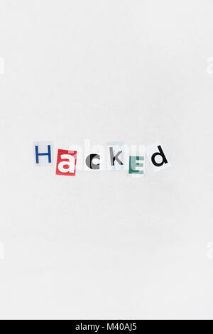 Hacked / Ransomware cutout letters message on sheet of plain newsprint. Ransomware message, ransom-ware attack, Russian hackers, China hackers. Stock Photo