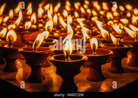 Oil lamps for the evening prayers burning at Boudhanath stupa, Kathmandu, Nepal. Stock Photo