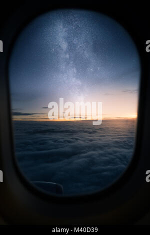 Beautiful view out of airplane window during sunrise with milky way on the sky Stock Photo