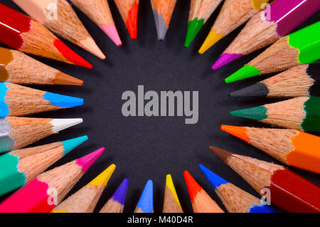 Circular colored pencils on black background Stock Photo